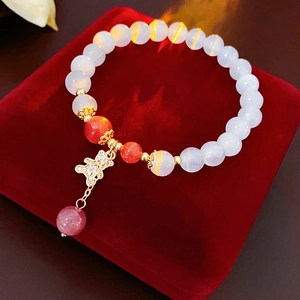 Detailed macro view of a beaded butterfly bracelet on a premium red velvet background