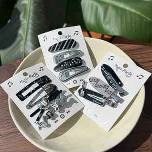 Close-up of music-themed hair clip set with piano and guitar motifs on display cards