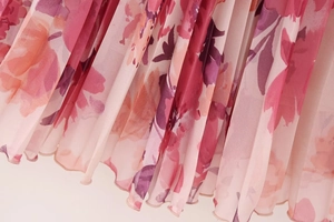 Dettaglio ravvicinato del tessuto in chiffon plissettato con vivaci stampe floreali rosa