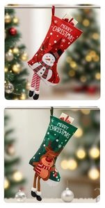 Detailed view of red snowman and green reindeer Christmas stockings with hanging long legs