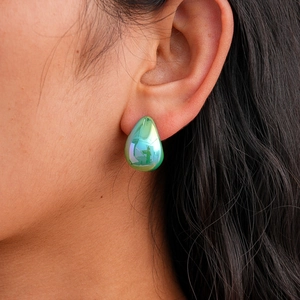 Close-up of teardrop acrylic earring with green aurora polarized finish and metallic luster