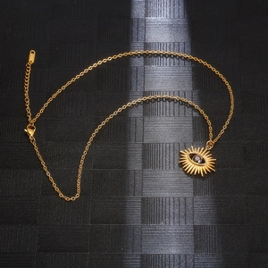 Detailed view of golden sun-shaped Evil Eye pendant on a sleek titanium steel chain