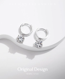 Detail of silver S925 drop earrings featuring round 1 carat moissanite stones
