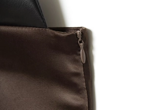 Detail of coffee and black patchwork top featuring a hidden zipper and leather texture