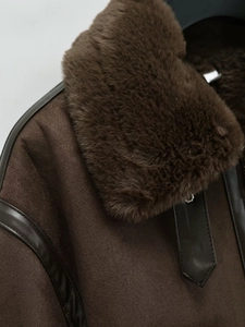 Detail of plush brown fur collar and suede texture on women's winter shearling jacket