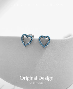 Détail de boucles d'oreilles cœur en argent S925 avec perles turquoise sur socle