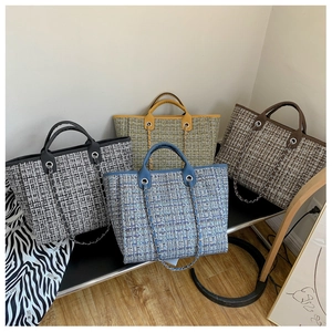 Detailed close-up of large wool tote bags with metal chain straps in four trendy colors
