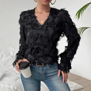 Detail of elegant black long sleeve blouse featuring fuzzy tassel and feather texture