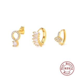 Macro detail of three 925 sterling silver gold earrings with cubic zirconia stones