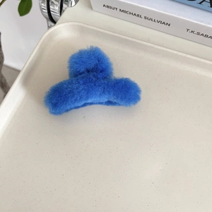 Detail der flauschigen Haarklammer in Klein-Blau mit Kunstfell-Textur auf Tablett