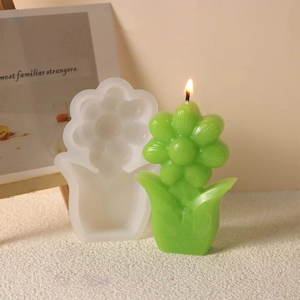 Detalle de la vela verde en forma de flor y su molde de silicona para manualidades DIY