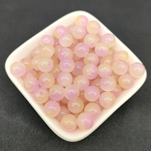 Macro shot of 8mm round translucent yellow and pink gradient glass beads for DIY jewelry