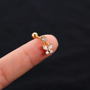 Macro shot of gold butterfly cartilage stud earring with clear zircon on model finger