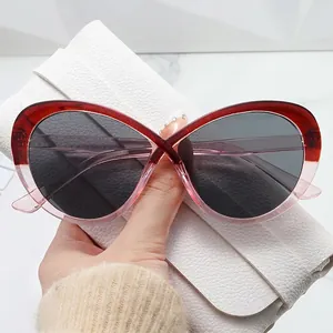 Occhiali da sole cat-eye oversize con ponte a X e montatura sfumata rosso-rosa alla moda
