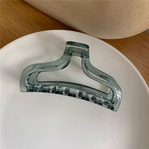 Close-up of a large translucent turquoise hair claw clip with a durable silver spring