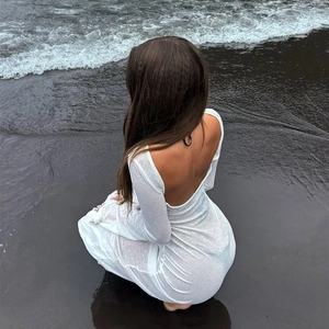 Dettaglio dell'abito lungo bianco senza schiena con tessuto testurizzato in spiaggia