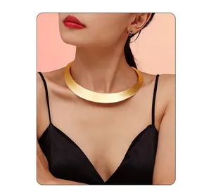 Golden punk choker necklace and colorful gem earrings on model with black strap top