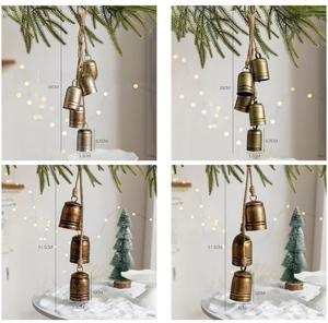 Close-up of vintage iron Christmas bells on twine with pine needles and warm lights