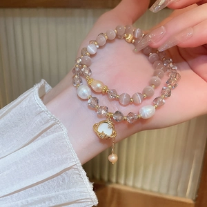 Détail d'un bracelet double couche avec œil de chat, perles d'eau douce et pendentif étoile