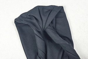 Close-up of black knitted twist detail on the backless irregular midi dress