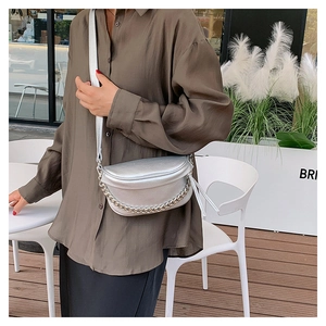 Silver crossbody chest bag with lychee texture and metal chain worn by a model