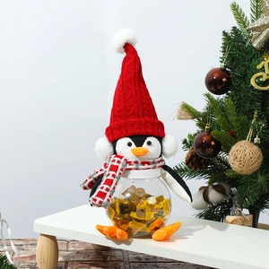 Detail of Christmas penguin candy jar with red knitted hat and transparent container