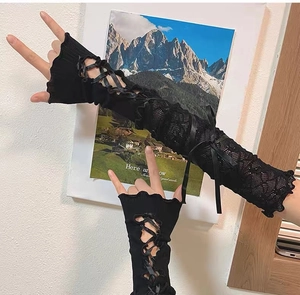 Detail of black Y2K lace arm warmers with satin ribbon ties and ruffled knit texture