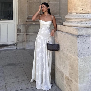 Detail of white evening dress featuring delicate 3D floral appliques and slim straps