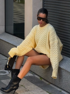 Detail of yellow chunky cable-knit sweater with oversized fit and crew neck design