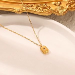 Macro detail of gold eight-pointed star pendant on white stone tray with retro frame