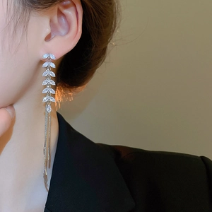 Detail of long silver leaf tassel earrings with sparkling zircon stones on a model