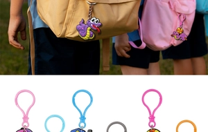 Detailed view of colorful cartoon snake PVC keychains attached to a backpack as accessories
