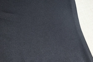 Macro shot of deep black fine-knit fabric texture for the sleeveless bodycon dress