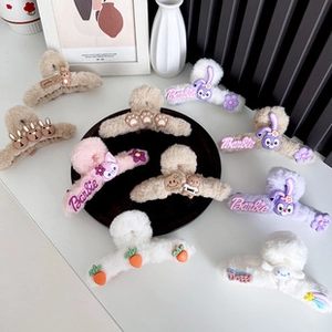 Close-up of plush wave hair claws with cartoon animals and embroidered brand lettering