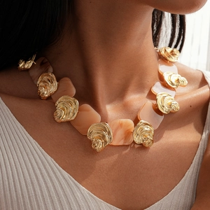 Detail of vintage resin pendant necklace with golden spiral metal accents on a model