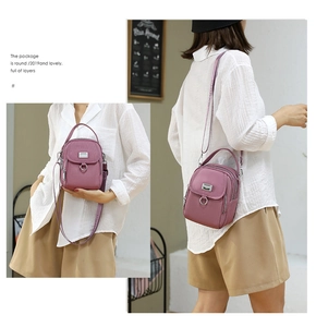 Pink oxford cloth crossbody bag detail featuring multiple layers and metal ring closure