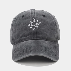 Detailed close-up of white sun embroidery on washed gray vintage baseball cap