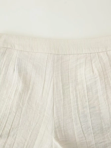 Detail view of the natural linen blend fabric texture and elastic waistband of the set