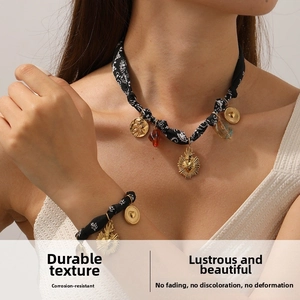 Detail of floral beaded necklace set with golden sacred heart and rose pendants