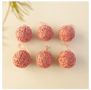 Close-up of 6-piece pink knitted wool Christmas balls with textured weaving patterns