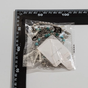 Detail of turquoise beaded necklace with bull skull pendant in product packaging