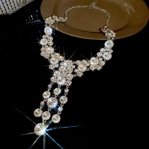 Close-up of sparkling Y-shaped tassel necklace with crystal pendants and silver finish