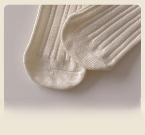 Detailed close-up of smooth seamless toe stitching on white ribbed cotton socks