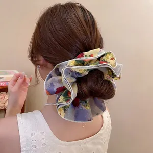 Floral print oversized chiffon scrunchie shown in a stylish retro bun hairstyle