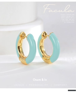 Detailed close-up of sky blue enamel hoop earrings with a polished golden finish
