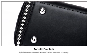 Close-up of black leather bag base featuring silver metal feet and smooth side zipper
