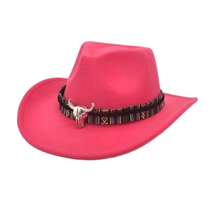 Detalle de sombrero vaquero rosa con banda tejida bohemia y accesorio de cabeza de toro