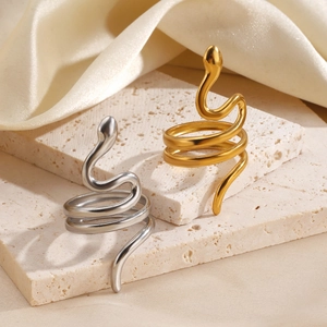 Bague serpent ethnique en or et argent posée sur une pierre avec décor en soie