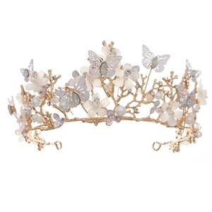 Detailed shot of golden crown featuring enamel flowers, crystals, and delicate butterflies
