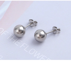 Macro shot of polished silver stainless steel ball earrings with smooth mirror finish